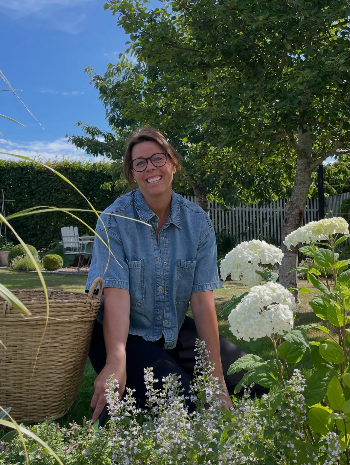 Helena Axnervik i sin trädgård bland hortensior och blommande perenner